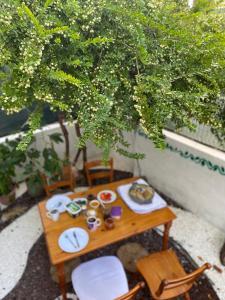 une table avec des assiettes de nourriture sous un arbre dans l'établissement Blue House - Mavi Ev, à Fethiye