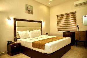 アブジャにあるMayFair Hotel Maitama Abujaの大きなベッドとデスクが備わるホテルルームです。
