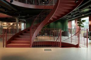 a spiral staircase in a building with a green wall at Ten Hotel BW Signature Collection in Upplands-Väsby