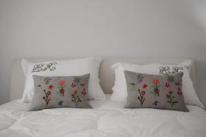 a white bed with two pillows on top of it at Lucy's House in Lousada