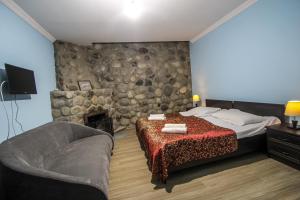 a bedroom with a bed and a stone wall at Hotel Svaneti in Mestia