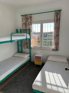 une chambre avec deux lits superposés et une fenêtre dans l'établissement CA LA CRISTI - 2 terrazas, piscina, wifi y barbacoa, à L'Escala