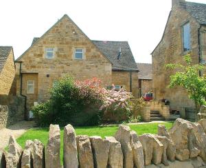 einen Steinzaun vor einem Haus in der Unterkunft Cotswold Charm Stable Cottage in Chipping Campden
