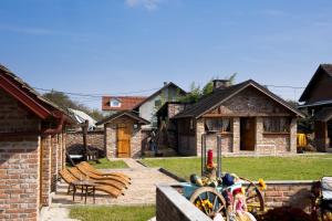 een huis met een tuin met stoelen en een patio bij River Side in Aljmaš