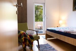 een slaapkamer met een bed, een stoel en een raam bij River Side in Aljmaš