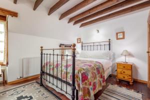 1 dormitorio con 1 cama y suelo de madera en The Granary - Quaint & Cosy Cottage, en Boarhills