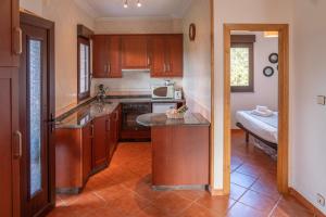 - une cuisine avec des placards en bois et un comptoir dans l'établissement Casa en la playa de Area con finca privada, à Viveiro