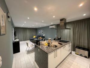 a kitchen with a sink and a living room at T3 Vilamoura in Vilamoura