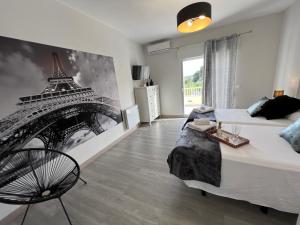 1 dormitorio con 1 cama y una foto de la torre Eiffel en Casa Rural Altaret, en Callosa de Ensarriá