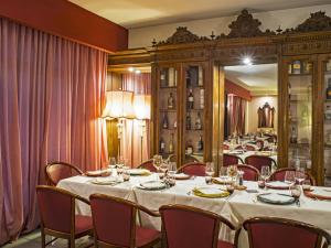 una sala da pranzo con tavolo, sedie e specchio di Hotel Giò Wine e Jazz Area a Perugia