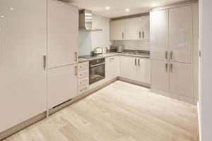 een keuken met witte kasten en een houten vloer bij Host & Stay - Fern in York +7 foto's