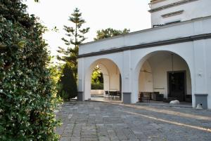 un edificio blanco con arcos y un patio en Casa Cicala, en Melito di Napoli