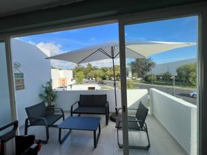 a patio with a table and chairs and an umbrella at T3 Vilamoura in Vilamoura