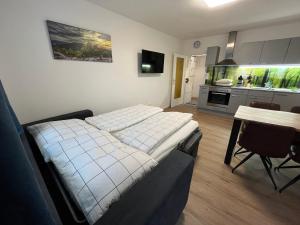 Zimmer mit 2 Betten, einem Tisch und einer Küche in der Unterkunft Modernes 4er Apartment in Skilift-Nähe in Zell am See