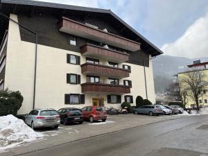 a large building with cars parked in a parking lot at Modernes 4er Apartment in Skilift-Nähe in Zell am See