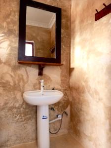 a bathroom with a sink and a mirror at Atlas Hotel Paje in Paje