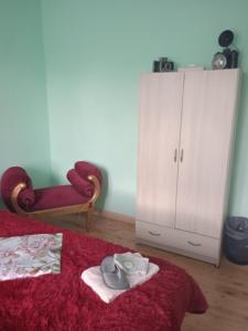 a bedroom with a red bed and a cabinet at Sweet home vintage in Charleroi