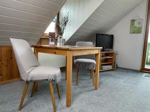 a desk with two chairs and a television in a room at Pension Grandel in Kottmar