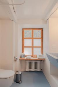 een badkamer met een toilet en een raam bij Corippo Albergo Diffuso 