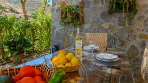 a table with a bowl of fruit and a bottle of wine at Casa Ana de Guaro by Ruralidays in Guaro