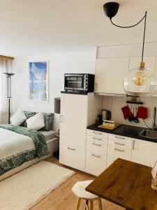 1 dormitorio con 1 cama y cocina con microondas en Your Pied-à-terre in Davos, en Davos