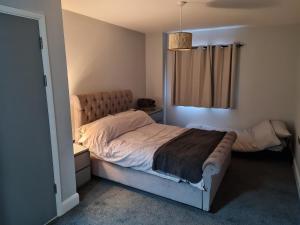 a bedroom with a large bed and a window at Luxury 2 Bedroom, and 2 Bathroom Apartment in Cardiff