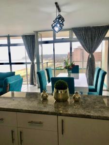 a kitchen with a table and some blue chairs at T' Primage Suite on Ten South in Durban