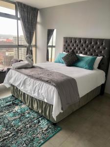 Un dormitorio con una cama grande con una ventana grande. en T' Primage Suite on Ten South, en Durban