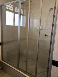 a shower with a glass door in a bathroom at T' Primage Suite on Ten South in Durban