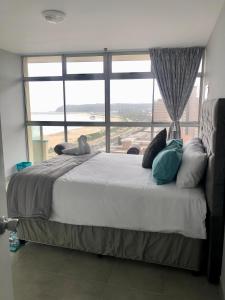 a bedroom with a large bed with a large window at T' Primage Suite on Ten South in Durban