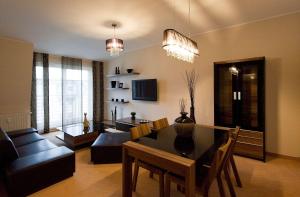 a living room with a dining table and a couch at Glamour Apartments Sopot in Sopot