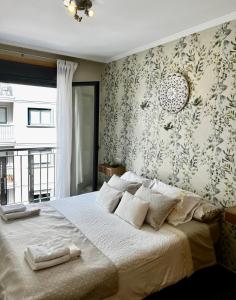 a bedroom with a large bed with a floral wallpaper at GIRALDA 2 in Ponteareas