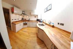 a large kitchen with wooden floors and white cabinets at South House in Winchester