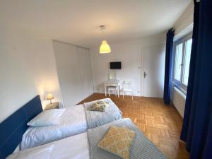 a bedroom with a bed and a table with chairs at Appartement Gare Strasbourg Parking in Strasbourg