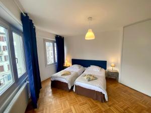 a bedroom with two beds and a large window at Appartement Gare Strasbourg Parking in Strasbourg