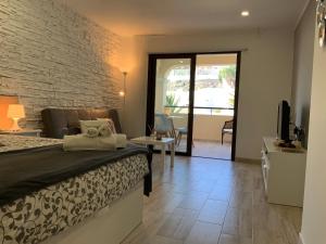 - une chambre avec un lit et un mur en briques dans l'établissement BOUTIQUE Apartment, à Los Cristianos
