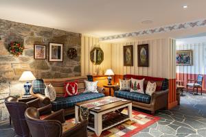 a living room with couches and a stone wall at The Cluanie Inn in Glenmoriston