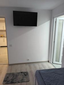 um quarto branco com uma televisão de ecrã plano na parede em apartament de lux em Lupeni
