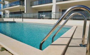 a swimming pool with a stairway leading to a building at Wave of happiness in São Martinho do Porto