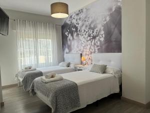 ein Schlafzimmer mit 2 Betten und einem Wandgemälde in der Unterkunft Casa Rural Altaret in Callosa d'en Sarrià
