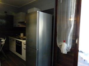 a kitchen with a stainless steel refrigerator with a towel on it at Appartamento Bel Sito in Bardolino +10 photos