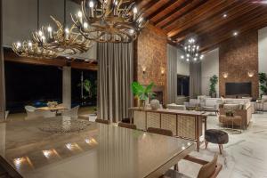 a large living room with chandeliers and a lobby at Casa Mantiqueira Hotel Boutique in Jacutinga