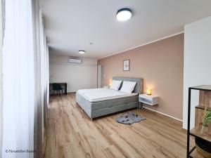 sypialnia z łóżkiem i drewnianą podłogą w obiekcie St. Antoni Suite 5 w mieście Eisenstadt