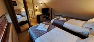 a hotel room with two beds and a mirror at South House in Winchester