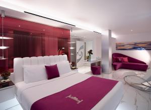 ein Schlafzimmer mit einem großen weißen Bett mit lila Akzenten in der Unterkunft I Resort Beach Hotel & Spa in Stalida + 37 Fotos