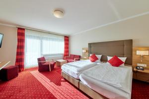 a hotel room with a large bed and chairs at Hotel Café Ernst in Bernkastel-Kues