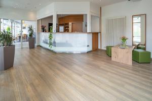 an office with a lobby with wooden floors and plants at Center Hotel Kaiserhof in Naumburg