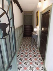 a hallway with a tiled floor and a door at L'ancienne Forge - a stylish medieval holiday home in Confolens