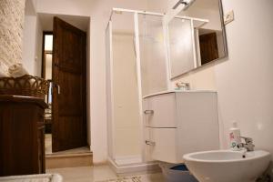 bagno con lavandino, specchio e frigorifero di Villa Rico Masseria nel Parco a Caramanico Terme