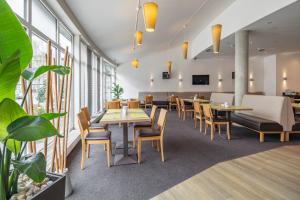 a dining room with tables and chairs and windows at Center Hotel Kaiserhof in Naumburg